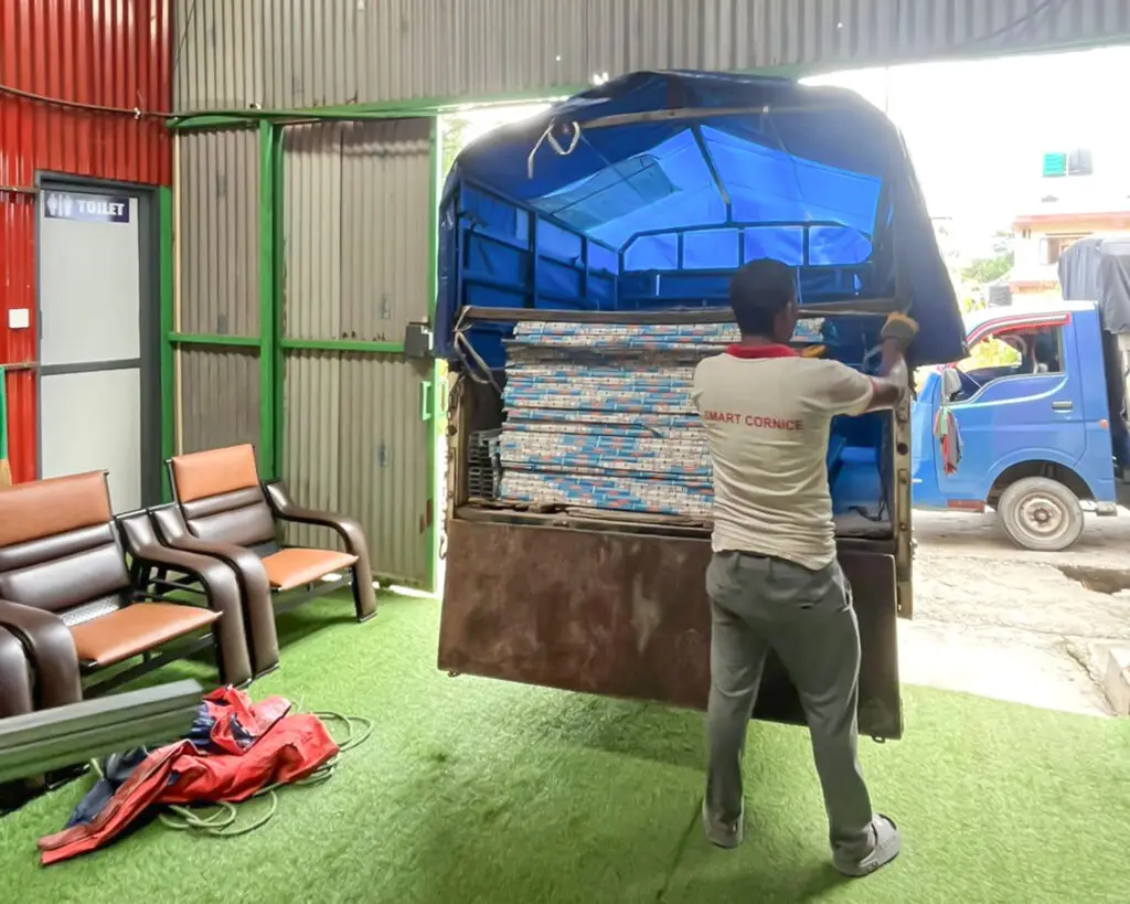 Man unloading plasterboard from a truck inside the NEVI Factory