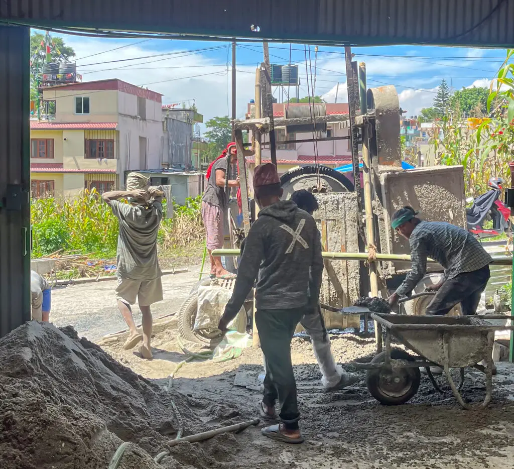 Group of workers with heavy machinery building the NEVI Factory in Nepal