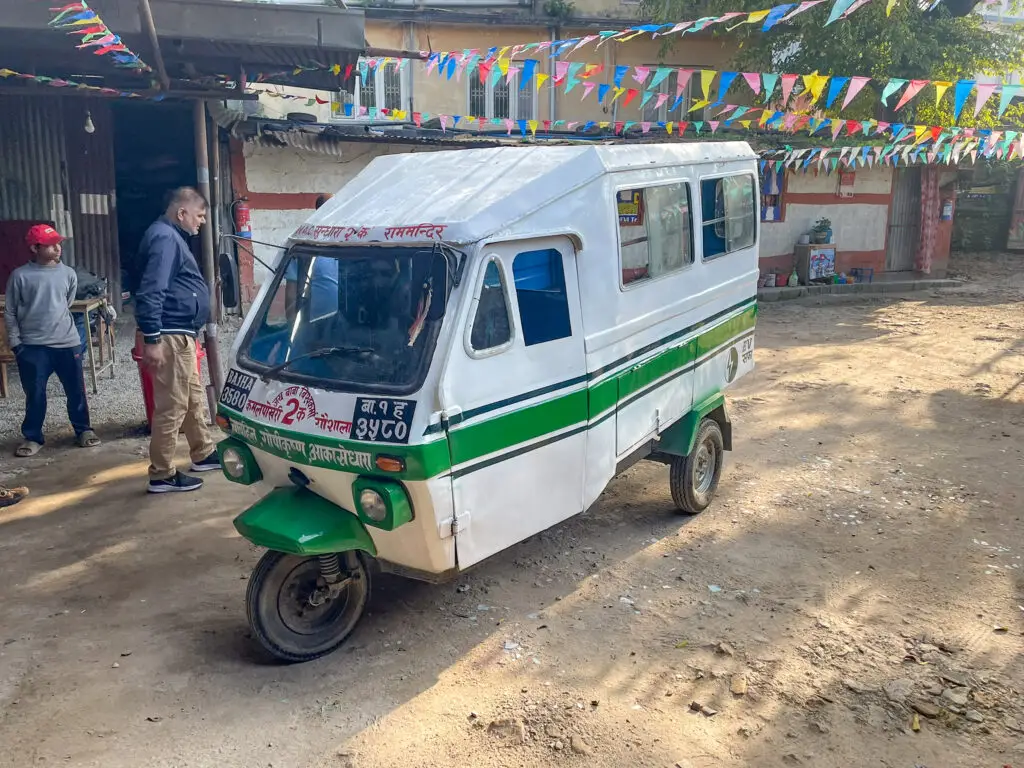 White with green stripe Electric rickshaw in Nepal used in Project GANESHA pilot for rural transport.