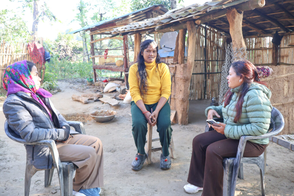 Three women seated outdoors in Bardiya, Nepal, in a small-group discussion as part of Project GANESHA community engagement.
